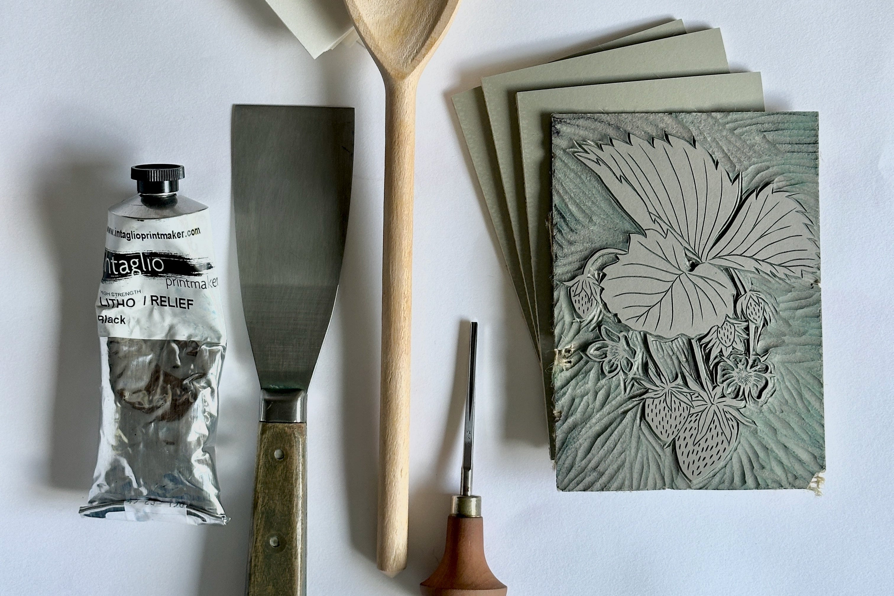 Wooden spoon, spatula, and textured cards on a white background